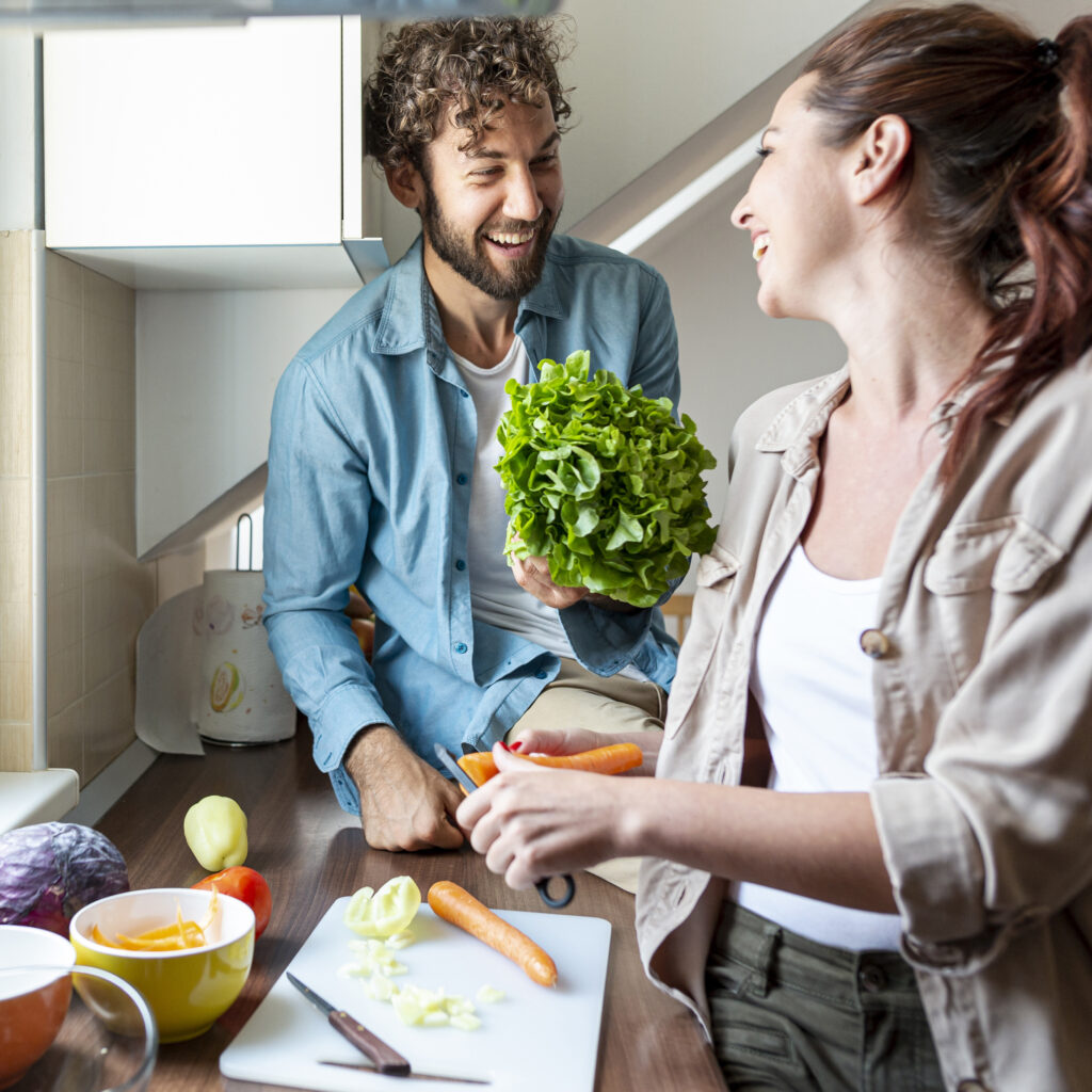 medium shot couple having fun cooking